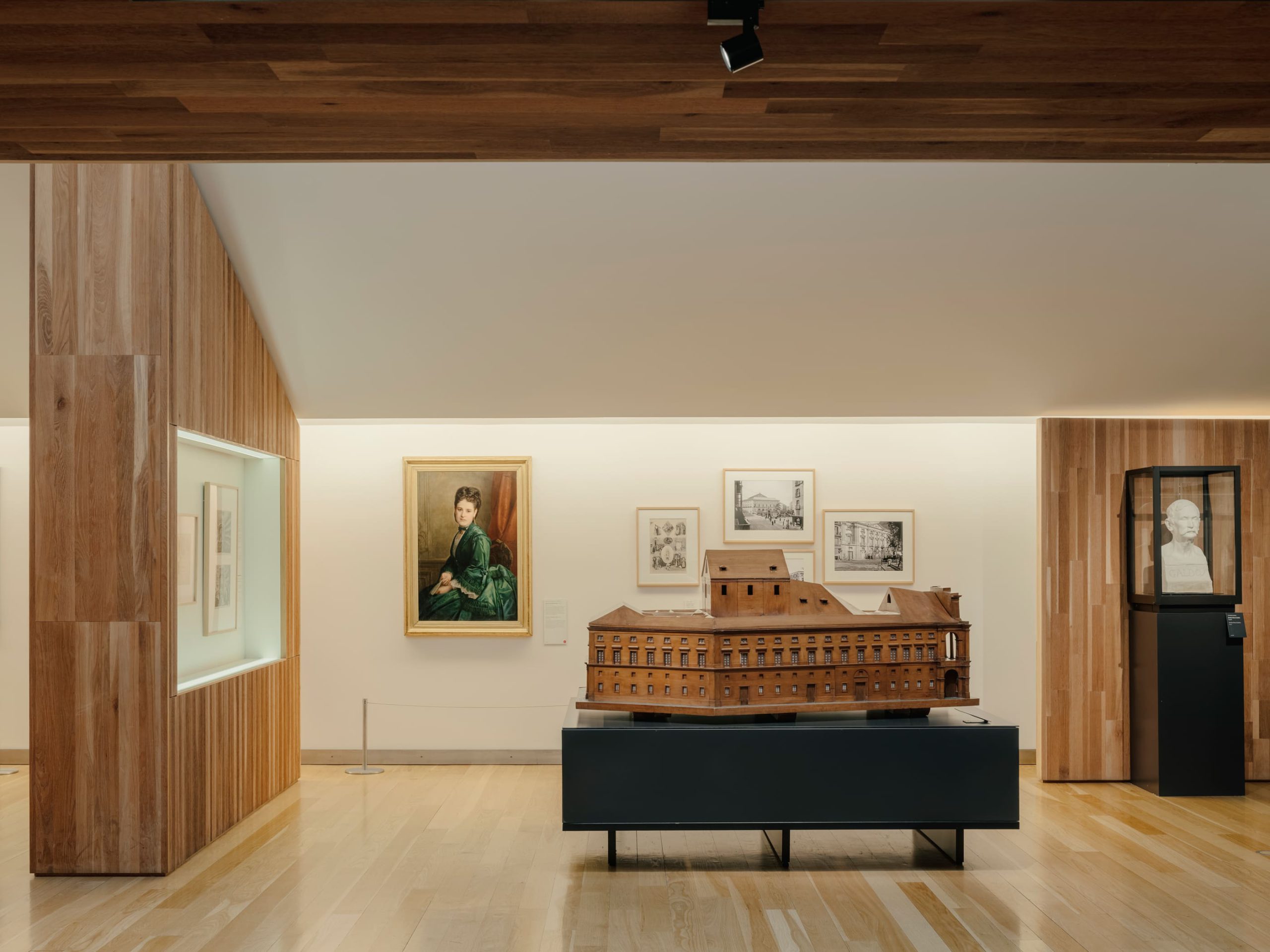 Sala de exposiciones con maqueta, cuadros y torso