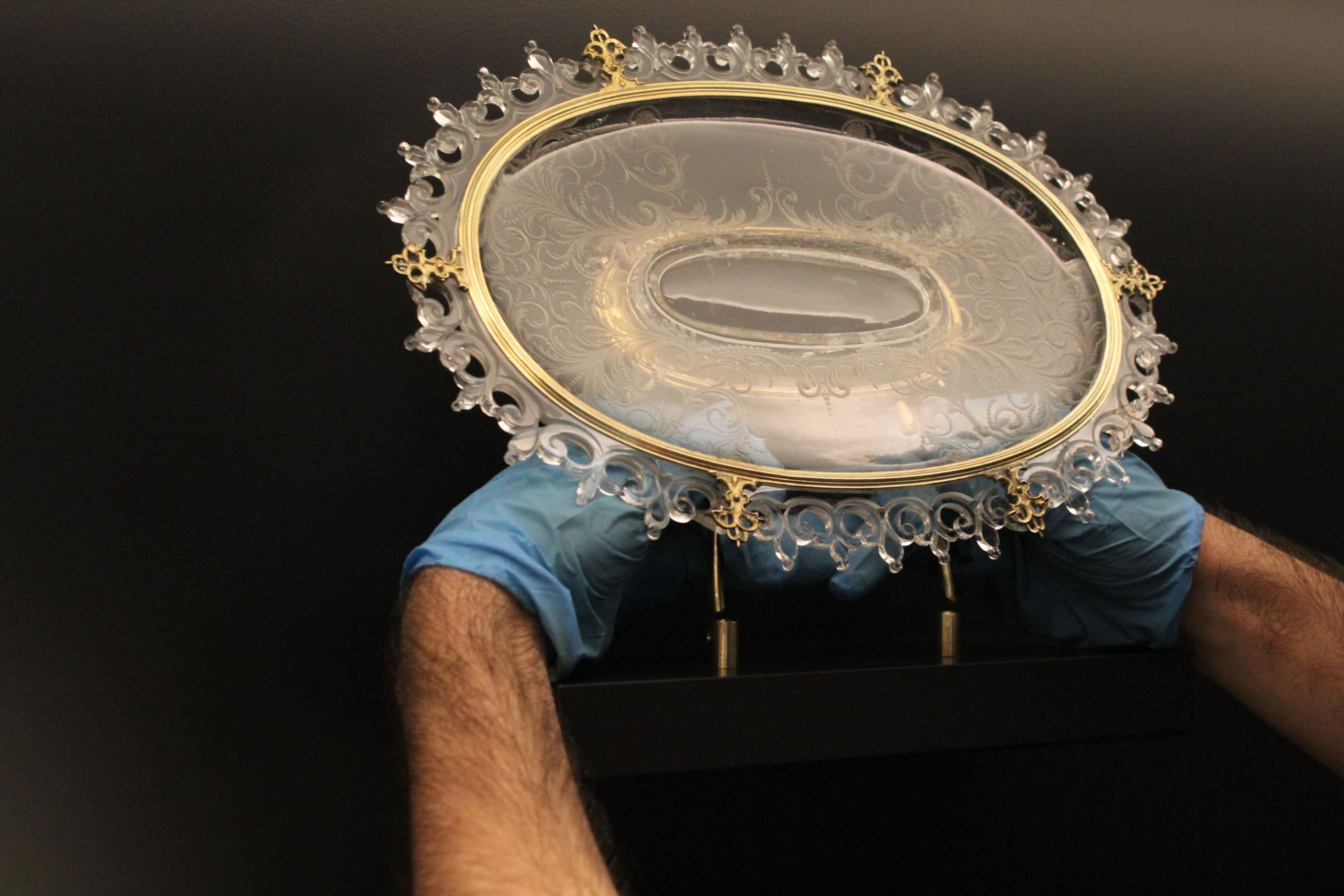 Técnico colocando pieza en vitrina para exposición Tesoro del Delfín