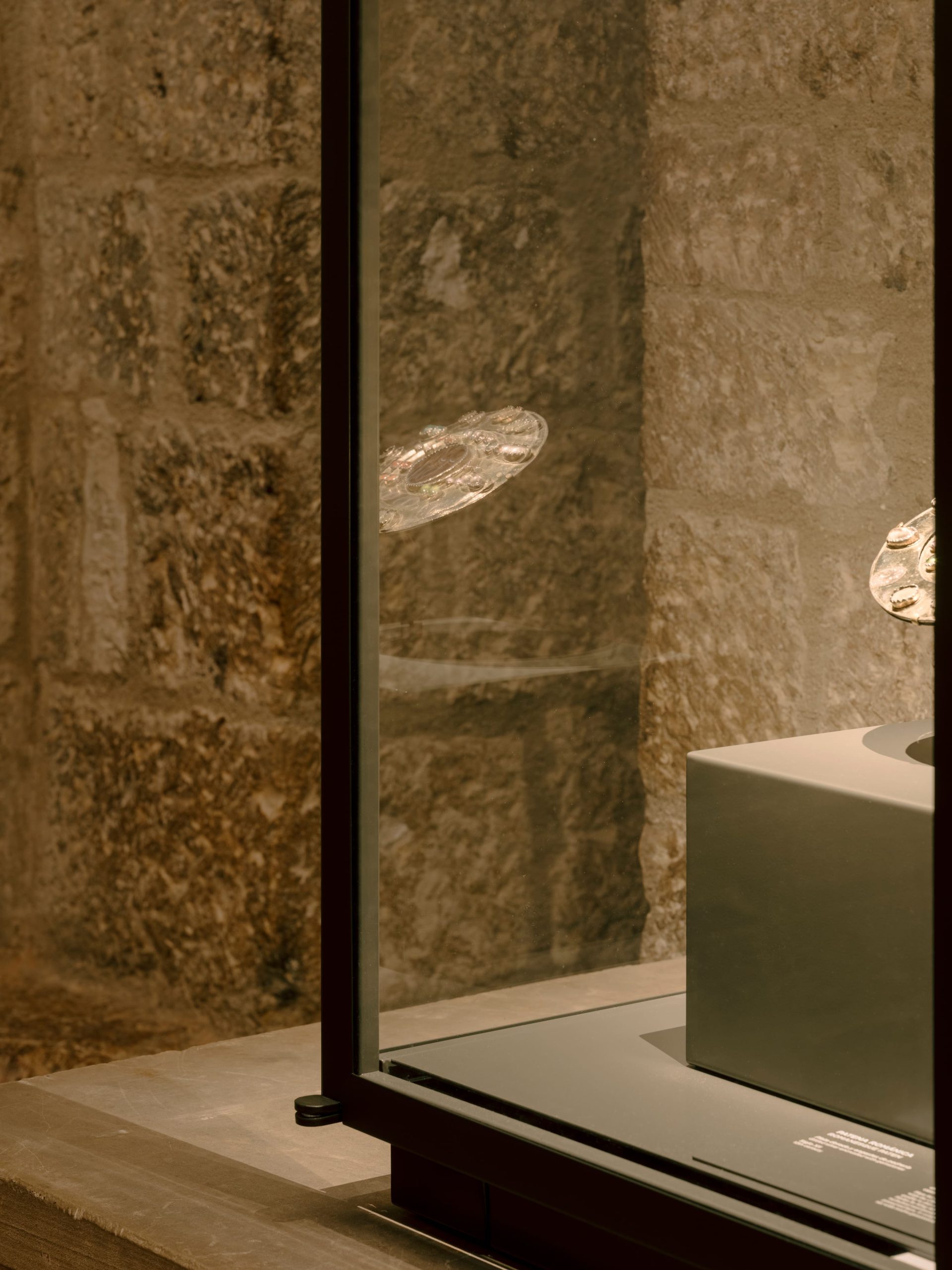 Reflejo de pieza artística en el cristal de una vitrina