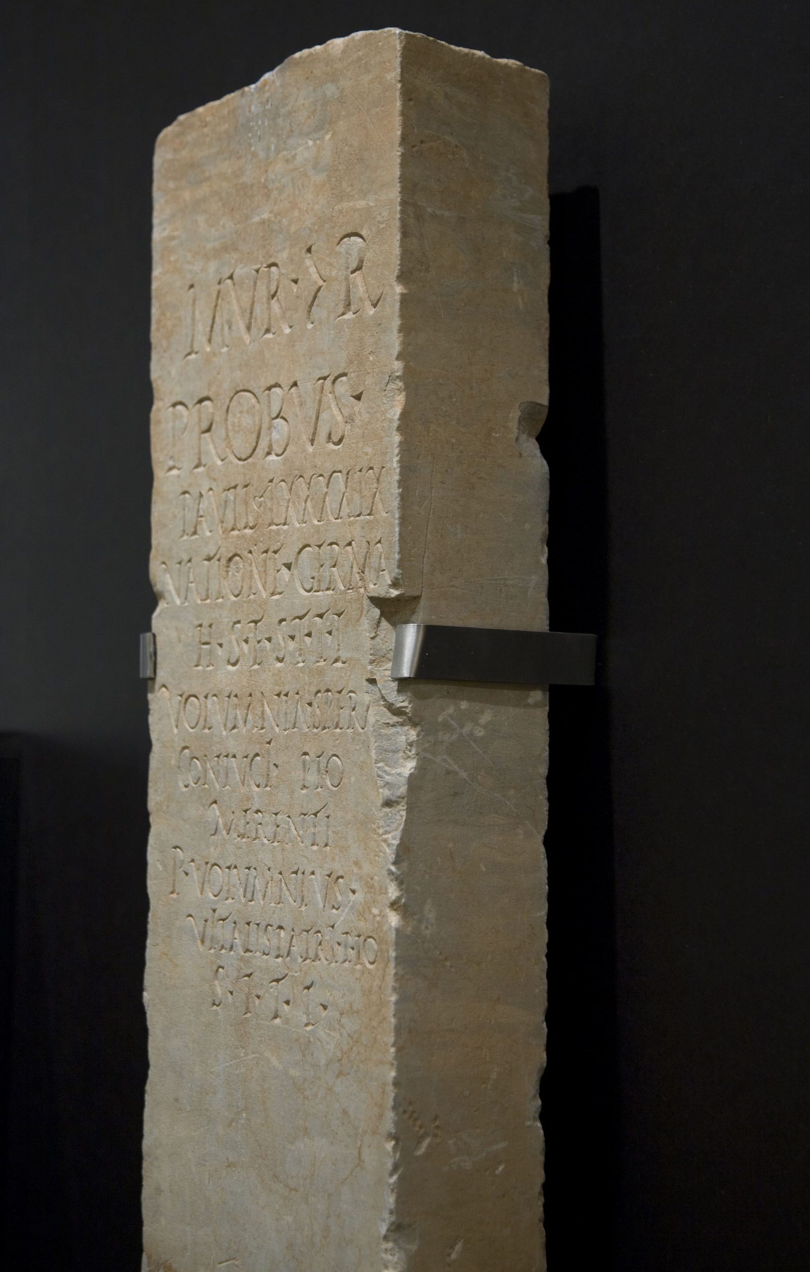 Piedra tallada con inscripción en latín y soporte